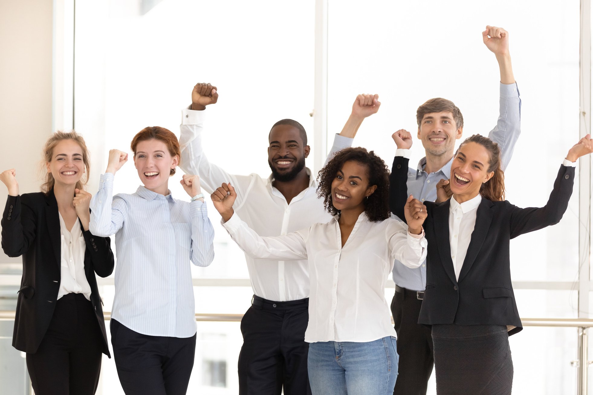 Happy diverse employees celebrating victory and success at work